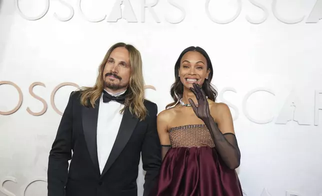 Marco Perego-Saldana, left, and Zoe Saldana arrive at the Oscars on Sunday, March 2, 2025, at the Dolby Theatre in Los Angeles. (AP Photo/Jae C. Hong)