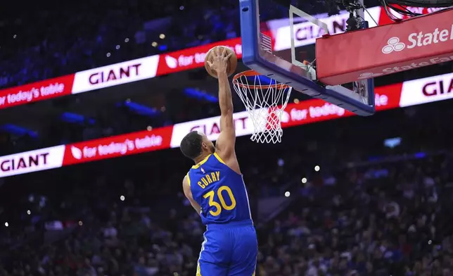 Golden State Warriors' Stephen Curry goes up for a dunk during the second half of an NBA basketball game against the Philadelphia 76ers Saturday, March 1, 2025, in Philadelphia. (AP Photo/Matt Slocum)