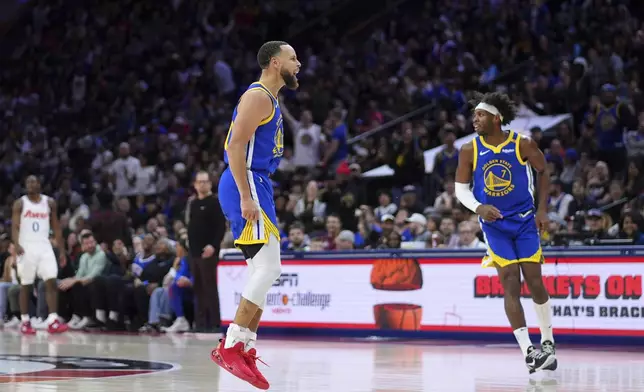 Golden State Warriors' Stephen Curry, center, reacts after a dunk during the second half of an NBA basketball game against the Philadelphia 76ers Saturday, March 1, 2025, in Philadelphia. (AP Photo/Matt Slocum)