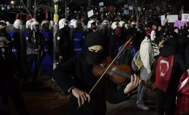A demonstrator plays the violin during a protest after Istanbul's Mayor Ekrem Imamoglu was arrested and sent to prison, in Istanbul, Turkey, Tuesday, March 25, 2025. (AP Photo/Khalil Hamra)