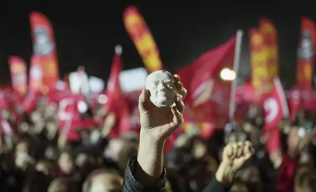 A protester holds a statue of Mustafa Kemal Ataturk during a protest after Istanbul's Mayor Ekrem Imamoglu was arrested and sent to prison, in Istanbul, Turkey, Tuesday, March 25, 2025. (AP Photo/Francisco Seco)