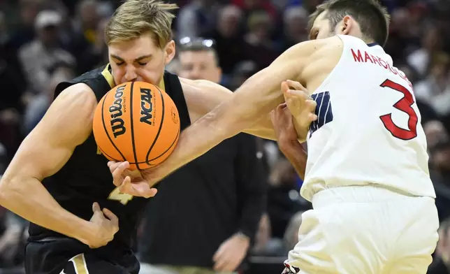 Saint Mary's guard Augustas Marciulionis (3) knocks the ball from Vanderbilt guard Grant Huffman (4) in the first half in the first round of the NCAA college basketball tournament, Friday, March 21, 2025, in Cleveland. (AP Photo/David Richard)