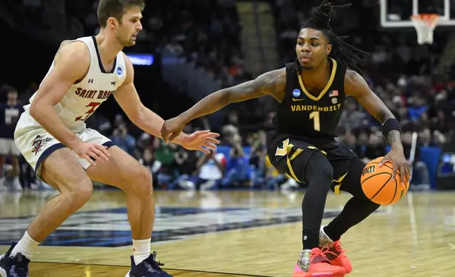 Saint Mary's guard Augustas Marciulionis (3) defends against Vanderbilt guard Jason Edwards (1) in the second half in the first round of the NCAA college basketball tournament, Friday, March 21, 2025, in Cleveland. (AP Photo/David Richard)