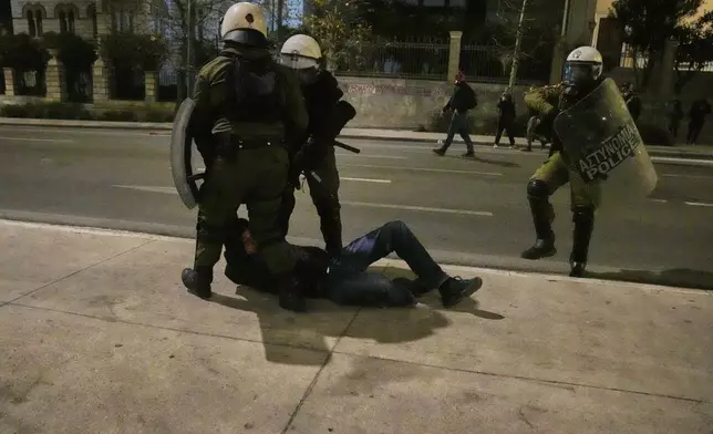 Riot policemen detain a protester during clashes, on the third and final day of a censure motion debate against the conservative government in parliament over a deadly rail disaster nearly two years ago, in Athens, Greece, Friday, March 7, 2025. (AP Photo/Petros Giannakouris)