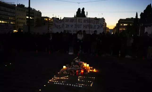 Protesters gather during a rally, on the third and final day of a censure motion debate against the conservative government in parliament over a deadly rail disaster nearly two years ago, in Athens, Greece, Friday, March 7, 2025. The number 57, formed by the candles, symbolizes the number of victims of the railway accident. (AP Photo/Petros Giannakouris)