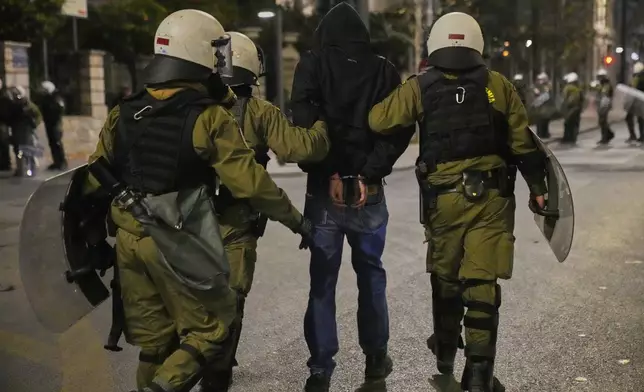 Riot policemen detain a protester during clashes, on the third and final day of a censure motion debate against the conservative government in parliament over a deadly rail disaster nearly two years ago, in Athens, Greece, Friday, March 7, 2025. (AP Photo/Petros Giannakouris)