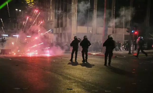 Protesters use fireworks against riot police during clashes, on the third and final day of a censure motion debate against the conservative government in parliament over a deadly rail disaster nearly two years ago, in Athens, Greece, Friday, March 7, 2025. (AP Photo/Petros Giannakouris)
