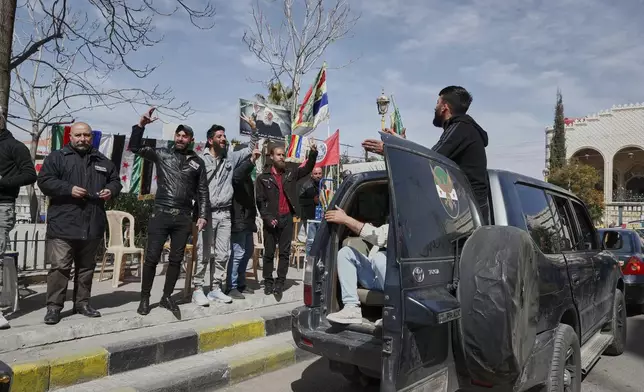 Druze men greet to members of the Rijal al-Karameh militia as they pass by Al Karama Square in the southern city of Sweida, Syria, March 4, 2025.(AP Photo/Omar Sanadiki)
