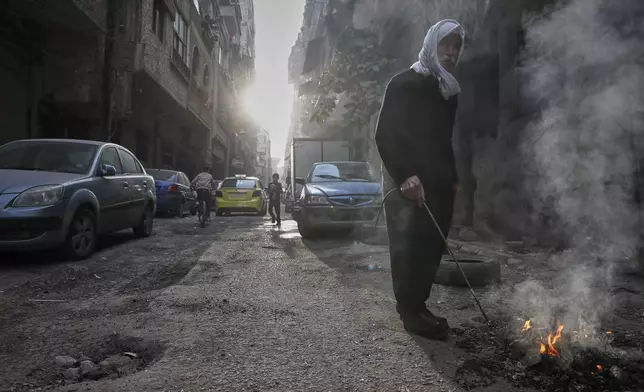 An elderly Druze man burns garbage in the town of Jaramana, in the southern outskirts of Damascus, Syria, March 3, 2025. (AP Photo/Omar Sanadiki)