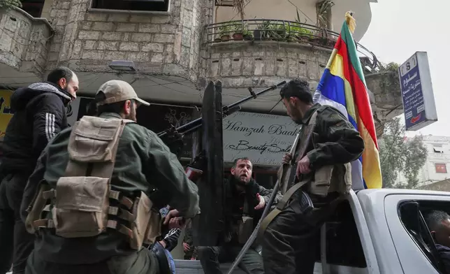 Druze fighters ride on a pick up truck holding a Druze flag as they wait for Syrian government security forces on the streets of the town of Jaramana, in the southern outskirts of Damascus, Syria, March 3, 2025. (AP Photo/Omar Sanadiki)