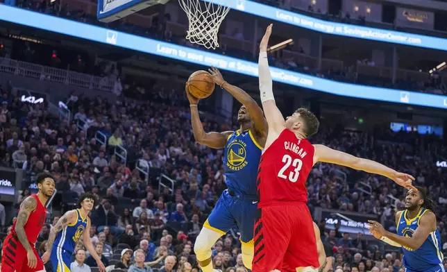 Golden State Warriors forward Jimmy Butler III (10) lays up a shot over Portland Trail Blazers center Donovan Clingan (23) during the first half of an NBA basketball game in San Francisco, Monday, March 10, 2025. (AP Photo/Nic Coury)