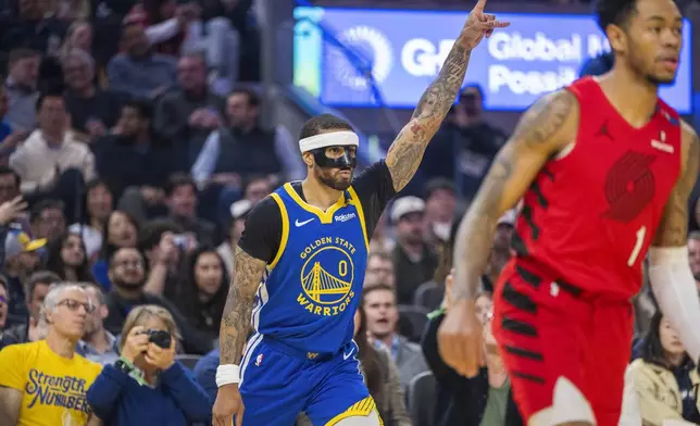 Golden State Warriors guard Gary Payton II (0) reacts after scoring as Portland Trail Blazers guard Anfernee Simons (1) looks on during the first half of an NBA basketball game in San Francisco, Monday, March 10, 2025. (AP Photo/Nic Coury)