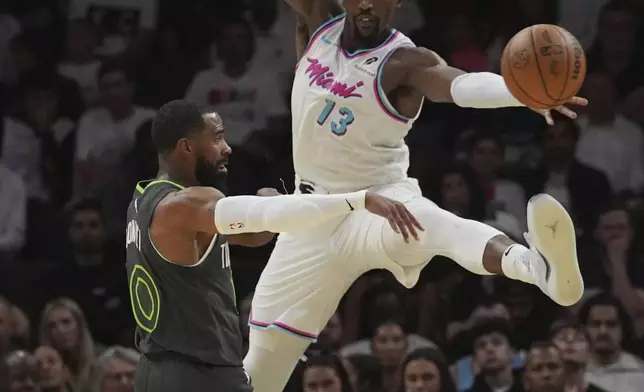 Minnesota Timberwolves guard Mike Conley (10) passes the ball as Miami Heat center Bam Adebayo (13) defends during the first half of an NBA basketball game, Friday, March 7, 2025, in Miami. (AP Photo/Marta Lavandier)