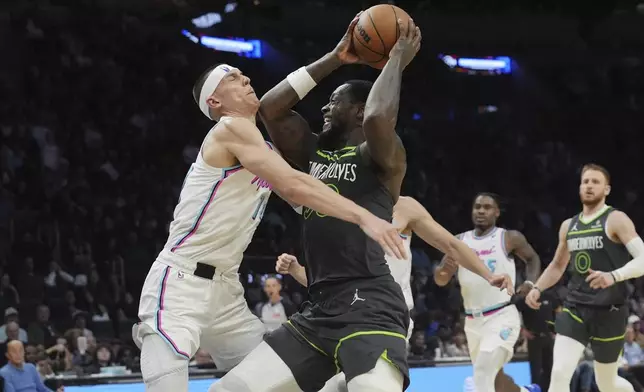 Miami Heat guard Tyler Herro (14) fouls Minnesota Timberwolves forward Julius Randle (30) during the second half of an NBA basketball game, Friday, March 7, 2025, in Miami. (AP Photo/Marta Lavandier)