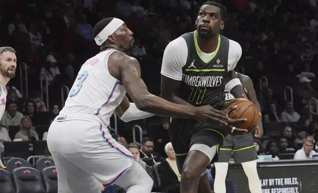 Minnesota Timberwolves center Naz Reid (11) drives to the basket as Miami Heat center Bam Adebayo (13) defends during the second half of an NBA basketball game, Friday, March 7, 2025, in Miami. (AP Photo/Marta Lavandier)