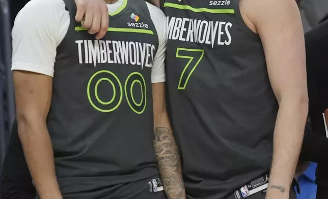 Minnesota Timberwolves guard Terrence Shannon Jr. (00) and guard Joe Ingles (7) celebrate after defeating the Miami Heat during an NBA basketball game, Friday, March 7, 2025, in Miami. (AP Photo/Marta Lavandier)