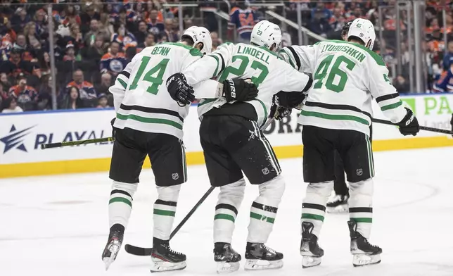 Dallas Stars' Esa Lindell (23) is helped off the ice by teammates Jamie Benn (14) and Ilya Lyubushkin (46) after being injured against the Edmonton Oilers during the second period of an NHL hockey game in Edmonton, Alberta, Saturday, March 8, 2025. (Jason Franson/The Canadian Press via AP)