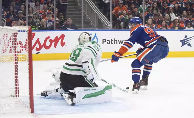 Dallas Stars goalie Jake Oettinger (29) is scored on by Edmonton Oilers' Connor McDavid (97) during the second period of an NHL hockey game in Edmonton, Alberta, Saturday, March 8, 2025. (Jason Franson/The Canadian Press via AP)