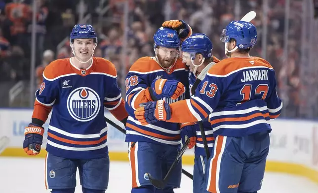 Edmonton Oilers' Ty Emberson (49), Connor Brown (28), Troy Stecher (51) and Mattias Janmark (13) celebrate after a goal against the Dallas Stars during second-period NHL hockey game action in Edmonton, Alberta, Saturday, March 8, 2025. (Jason Franson/The Canadian Press via AP)