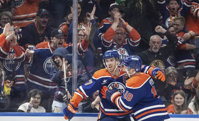Edmonton Oilers' Connor McDavid (97) and Zach Hyman (18) celebrate a goal against the Dallas Stars during the second period of an NHL hockey game in Edmonton, Alberta, Saturday, March 8, 2025. (Jason Franson/The Canadian Press via AP)