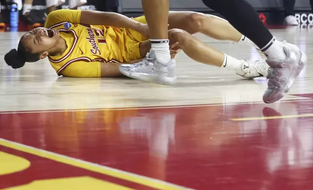 Southern California guard JuJu Watkins (12) reacts on the floor after an injury as Mississippi State guard Chandler Prater watches during the first half in the second round of the NCAA college basketball tournament Monday, March 24, 2025, in Los Angeles. (AP Photo/Jessie Alcheh)