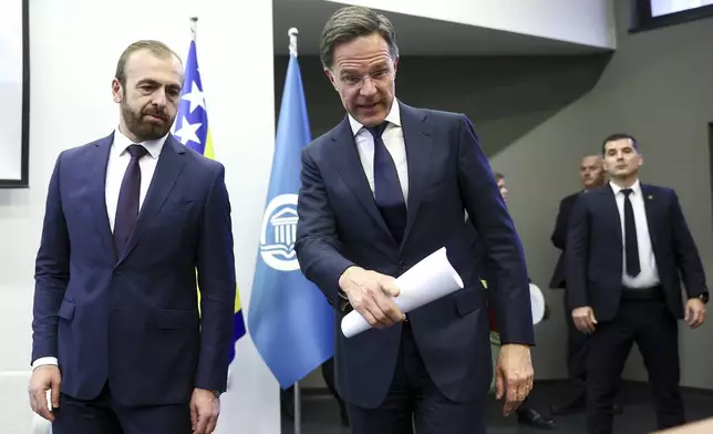 NATO Secretary General Mark Rutte, right, arrives with Sead Turcalo, dean of the Faculty of Political Sciences, to give a lecture to students in Sarajevo, Bosnia, Monday, March 10, 2025. (AP Photo/Armin Durgut)