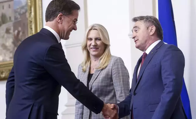 NATO Secretary General Mark Rutte, left, shakes hands with the member of the Bosnian Presidency Zeljko Komsic, right, prior to the start of their meeting in Sarajevo, Bosnia, Monday, March 10, 2025. (AP Photo/Armin Durgut)