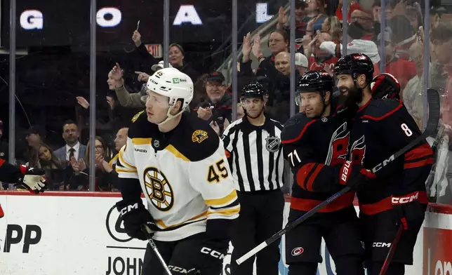 Carolina Hurricanes' Brent Burns (8) celebrates his goal with teammate Taylor Hall (71) as Boston Bruins' Cole Koepke (45) skates away during the second period of an NHL hockey game in Raleigh, N.C., Thursday, March 6, 2025. (AP Photo/Karl DeBlaker)
