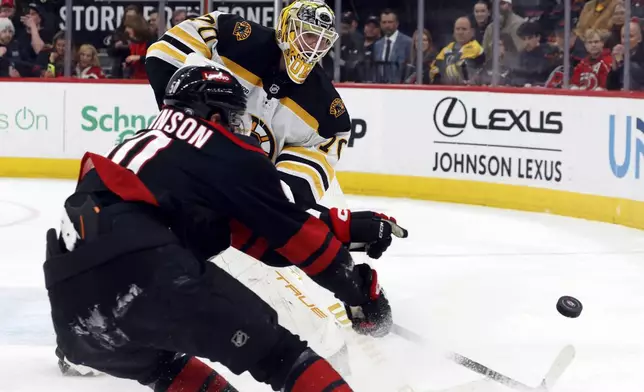 Boston Bruins goaltender Joonas Korpisalo (70) clears the puck away from Carolina Hurricanes' Eric Robinson (50) during the second period of an NHL hockey game in Raleigh, N.C., Thursday, March 6, 2025. (AP Photo/Karl DeBlaker)