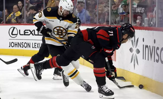 Carolina Hurricanes' Taylor Hall (71) battles Boston Bruins' Parker Wotherspoon (29) for the puck during the second period of an NHL hockey game in Raleigh, N.C., Thursday, March 6, 2025. (AP Photo/Karl DeBlaker)