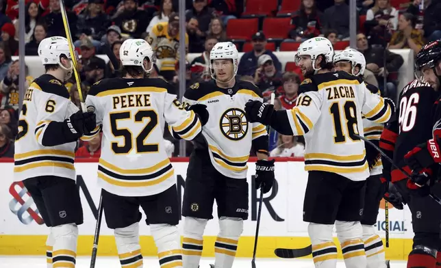 Boston Bruins' Morgan Geekie, center, celebrates after his goal with teammates during the first period of an NHL hockey game against the Carolina Hurricanes in Raleigh, N.C., Thursday, March 6, 2025. (AP Photo/Karl DeBlaker)
