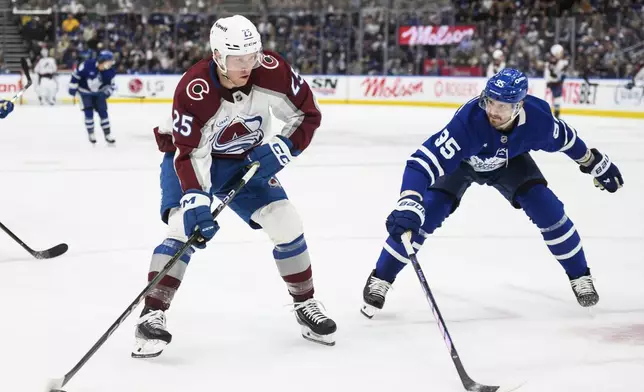 Colorado Avalanche's Logan O'Connor (25) looks to shoot while Toronto Maple Leafs' Oliver Ekman-Larsson (95) defends during first period NHL hockey action in Toronto on Wednesday, March 19, 2025. (Christopher Katsarov/The Canadian Press via AP)