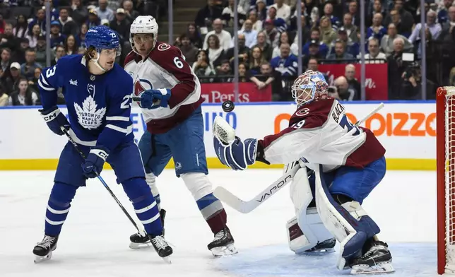 Colorado Avalanche goaltender Mackenzie Blackwood (39) makes a save on Toronto Maple Leafs' Matthew Knies (23) while Avalanche's Erik Johnson (6) looks on during the second period of an NHL hockey game in Toronto on Wednesday, March 19, 2025. (Christopher Katsarov/The Canadian Press via AP)