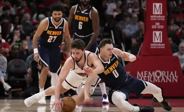 Houston Rockets center Alperen Sengun (28) and Denver Nuggets guard Christian Braun (0) dive after a loose ball during the first half of an NBA basketball game in Houston, Sunday, March 23, 2025. (AP Photo/Ashley Landis)