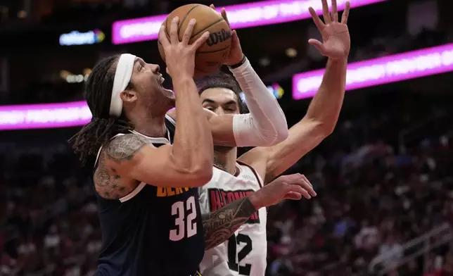 Denver Nuggets forward Aaron Gordon (32) shoots against Houston Rockets center Steven Adams (12) during the first half of an NBA basketball game in Houston, Sunday, March 23, 2025. (AP Photo/Ashley Landis)