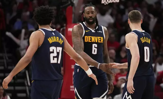 Denver Nuggets center DeAndre Jordan (6) celebrates with guard Jamal Murray (27) and guard Christian Braun (0) during the second half of an NBA basketball game against the Houston Rockets in Houston, Sunday, March 23, 2025. (AP Photo/Ashley Landis)