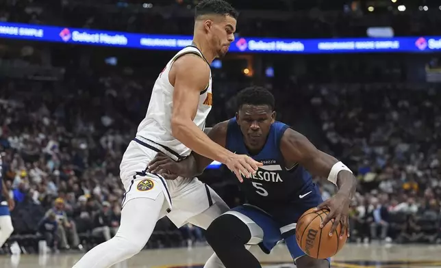 Minnesota Timberwolves guard Anthony Edwards, right, drives the lane as Denver Nuggets forward Michael Porter Jr. defends in the second half of an NBA basketball game Wednesday, March 12, 2025, in Denver. (AP Photo/David Zalubowski)