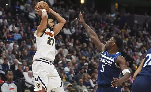 Denver Nuggets guard Jamal Murray, left, passes the ball as Minnesota Timberwolves guard Anthony Edwards defends in the first half of an NBA basketball game Wednesday, March 12, 2025, in Denver. (AP Photo/David Zalubowski)