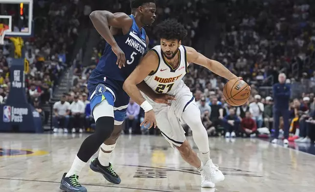 Denver Nuggets guard Jamal Murray, right, drives past Minnesota Timberwolves guard Anthony Edwards in the first half of an NBA basketball game Wednesday, March 12, 2025, in Denver. (AP Photo/David Zalubowski)
