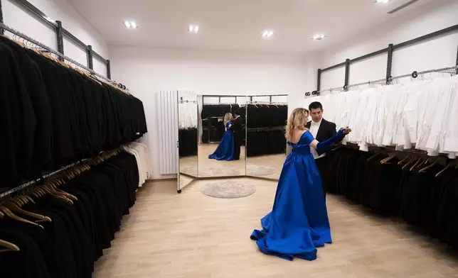 A young couple dance in the fitting room of Lambert Hofer, a renowned costume workshop in Vienna, Austria, Wednesday, Febr 26, 2025. (AP Photo/Denes Erdos)