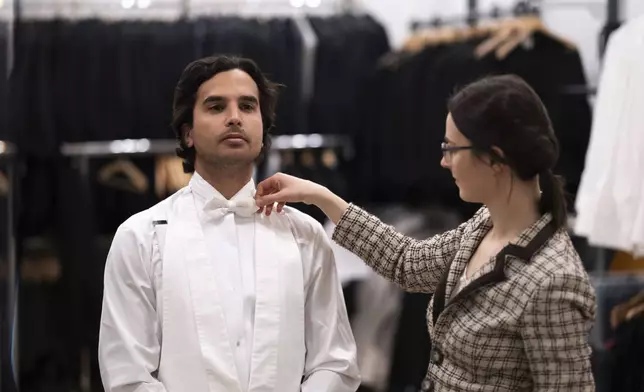 A man tries on his tailcoat before renting from Lambert Hofer, a renowned costume workshop in Vienna, Austria, Wednesday, Febr 26, 2025. (AP Photo/Denes Erdos)