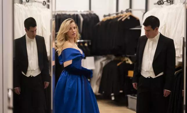A young couple watch themselves in the mirror during their fitting in Lambert Hofer, a renowned costume workshop in Vienna, Austria, Wednesday, Febr 26, 2025. (AP Photo/Denes Erdos)
