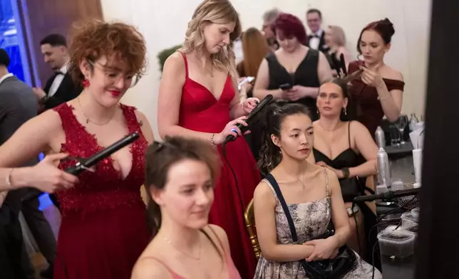 Women adjust each others hair during the Lawyers' Ball in Vienna, Austria, Saturday, March 1, 2025. (AP Photo/Denes Erdos)