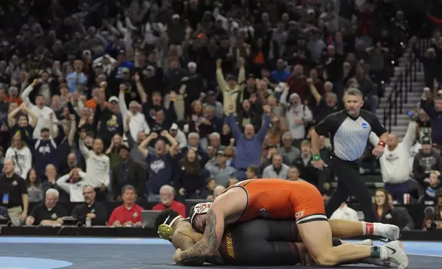 Oklahoma State's Wyatt Hendrickson, top, takes on Minnesota's Gable Steveson during a 285-pound match in the finals at the NCAA wrestling championship, Saturday, March 22, 2025, in Philadelphia. (AP Photo/Matt Rourke)