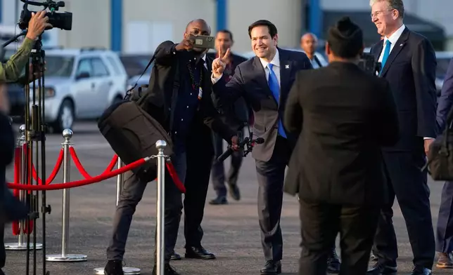 U.S. Secretary of State Marco Rubio poses for a photo before boarding an aircraft at Johan Adolf Pengel International Airport in Paramaribo, Suriname, Thursday, March 27, 2025. (Nathan Howard/Pool photo via AP)