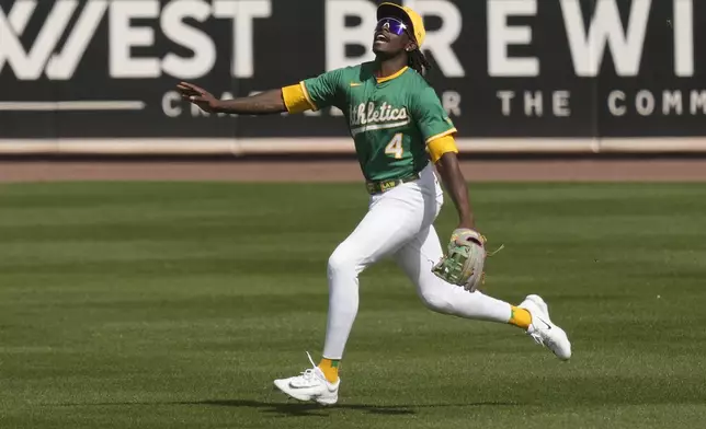 Athletics right fielder Lawrence Butler shouts runs to catch a fly ball hit by Cincinnati Reds' Jeimer Candelario during the second inning of a spring training baseball game, Friday, Feb. 28, 2025, in Mesa, Ariz. (AP Photo/Carolyn Kaster)