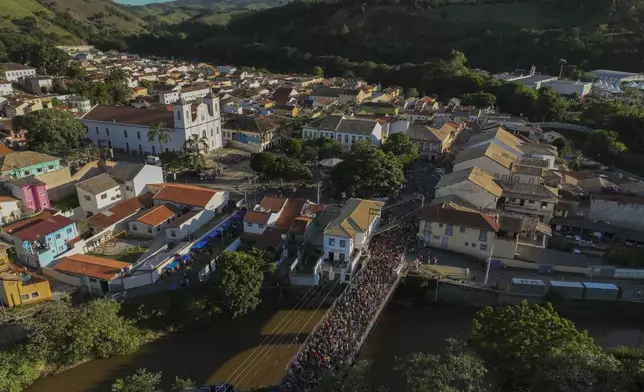 Revelers gather on a bridge during Carnival in Sao Luiz do Paraitinga, Brazil, Sunday, March 2, 2025. (AP Photo/Andre Penner)