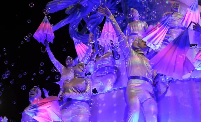 Dancers from the Colorado do Bras samba school perform on a float during a carnival parade in Sao Paulo, Friday, Feb. 28, 2025. (AP Photo/Andre Penner)