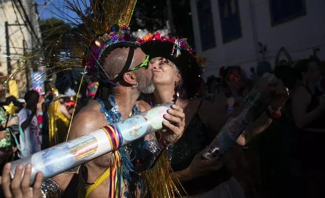 Musicians greet each other with a kiss during the "Ceu na Terra" or "Heaven on Earth" Carnival street party in Rio de Janeiro, Saturday, March 1, 2025. (AP Photo/Bruna Prado)