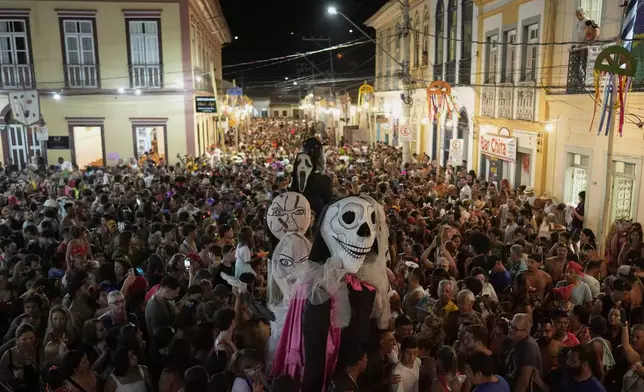 Revelers gather in a street during Carnival in Sao Luiz do Paraitinga, Brazil, Sunday, March 2, 2025. (AP Photo/Andre Penner)